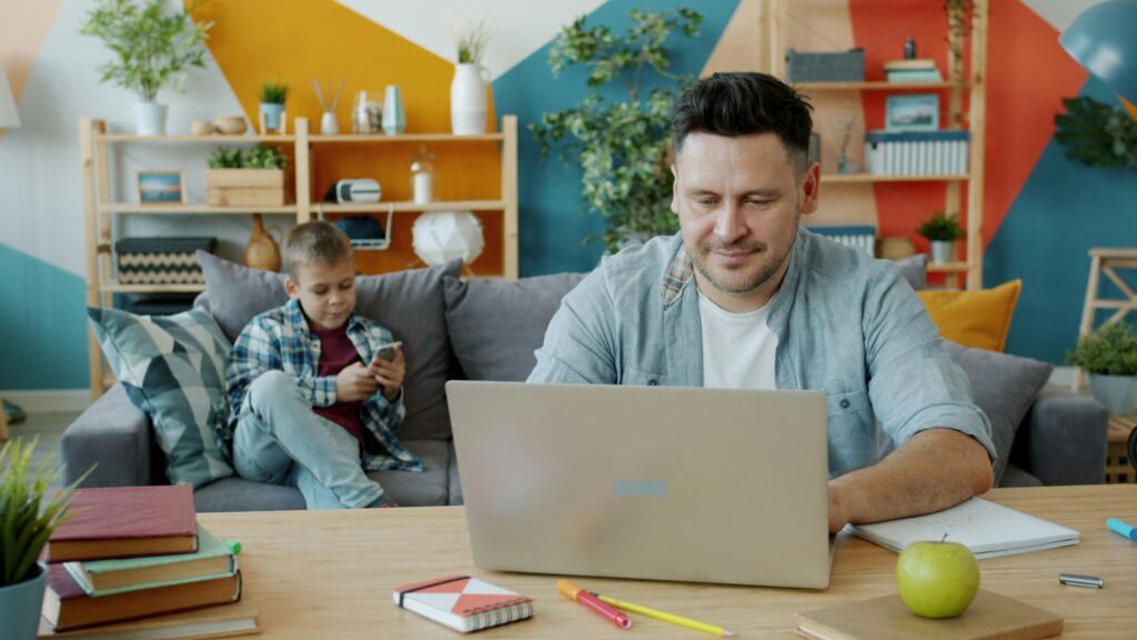 man on laptop with kid on phone